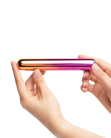 Sensuelle Aluminium Rumba Double Motor Ombre Warming Bullet held in hands, showcasing its sleek rainbow ombre design.