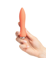 Nu Sensuelle 60SX Amp Silicone Bullet Coral held in hand, showcasing its sleek design and coral color.