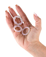 Fantasia Intensity Cock Rings Pearl displayed in a hand, showcasing their flexible design and luxurious shimmer.