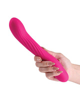 INYA Wiggle Stick Gyrating Silicone Vibrator Pink held in hand, showcasing its flexible silicone body and ribbed shaft.