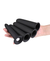 A hand holding the four-piece set of Renegade Vibrating Dilators Black in various sizes.