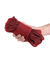 Bound 50 ft Bondage Rope Red held in a hand, showcasing its vibrant color and smooth texture.