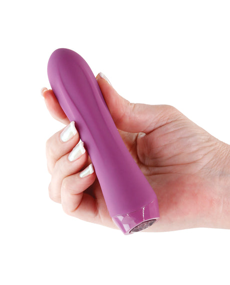 NS Novelties Charms Fern Ruby Clitoral Vibrator held in hand, showcasing its sleek design and premium silicone.