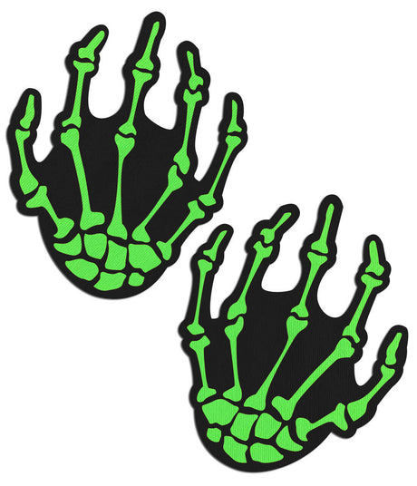 Pastease Neon Green Skeleton Hands Nipple Pasties with bony green designs on a black background.