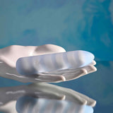 Playboy Unicorn Vibes Silicone Vibrating Bullet Blue resting in a hand against a soft blue background.