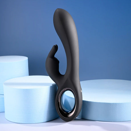 Playboy Late Night Bunny Silicone Rabbit Vibrator Black on blue backdrop with round foam shapes.