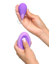 Woman holding Fantasy For Her Remote Kegel Excite-Her Purple in one hand and the remote in the other hand.