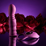 Playboy Match Play Silicone Dual Vibrator Purple on a reflective surface surrounded by red roses.
