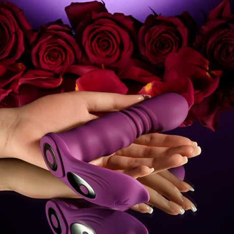 Playboy Match Play Silicone Dual Vibrator Purple surrounded by red roses, showcasing its dual function and elegant design.