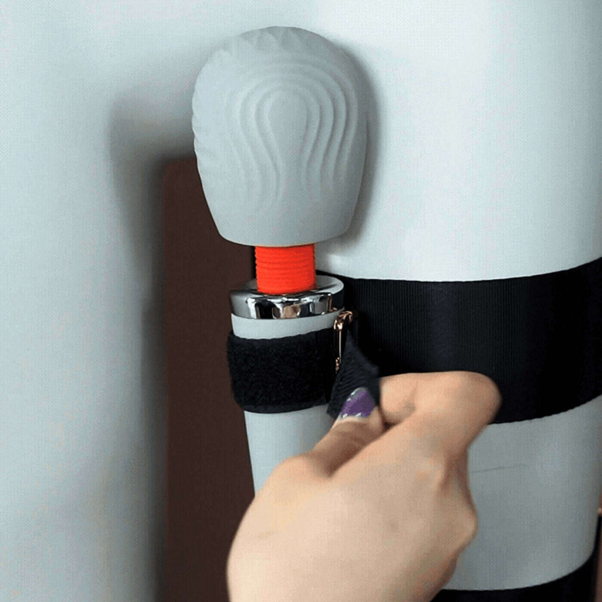 Close-up of UPKO Remote-Control Wand Vibrator being secured in thigh harness for enhanced pleasure experience.