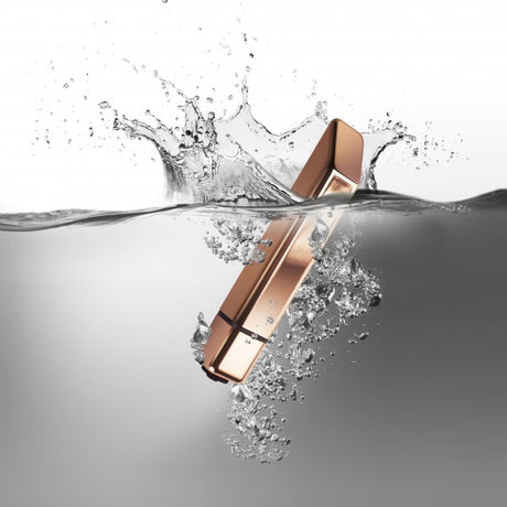 Rocks Off Bamboo 10 Speed Rose Gold Vibrator splashing into water with a luxurious rose gold finish.