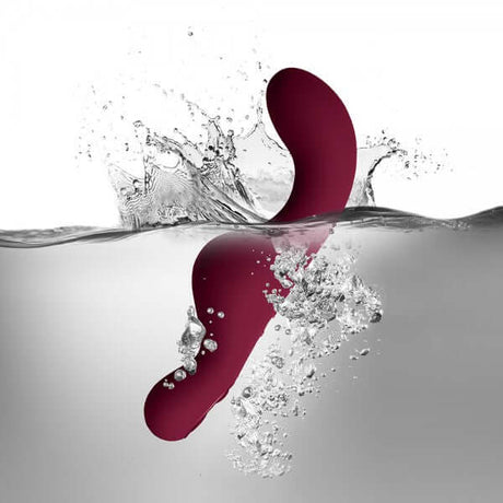 Rocks Off Ruby Glow Dusk 10 Speed Ride On Vibrator splashing in water, showcasing its design and features.