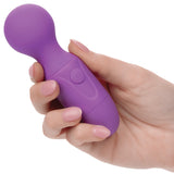 A hand holding the First Time Rechargeable Silicone Massager Purple, showcasing its compact size and design.