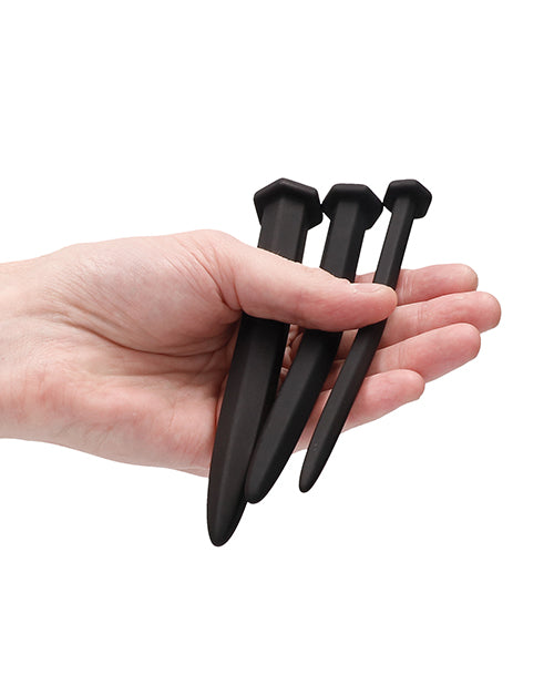 Ouch Silicone Rugged Nail Plug Set Urethral Sounding Black displayed in a hand showcasing its three-piece design.