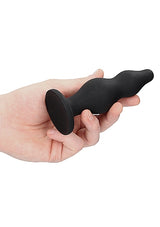 Ouch Silicone Bubble Butt Plug Black held in hand, showcasing its sleek design and body-safe silicone material.