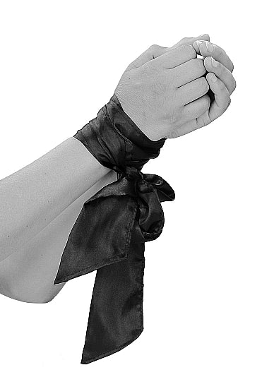 Ouch Black & White Bondage Silky Ribbon tied around wrists for elegant restraint.
