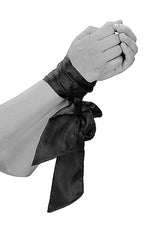 Ouch Black & White Bondage Silky Ribbon tied around wrists for elegant restraint.