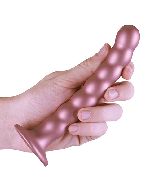 Shots Ouch 6.5 inch Beaded G-Spot Dildo Rose Gold held in a hand, showcasing its elegant design and beaded texture.