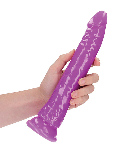 RealRock 10 inch Slim Dildo Glow in the Dark Neon Purple held in hand for a demonstration of its unique design.