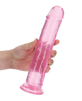 RealRock Crystal Clear 9 Inch Dildo Suction Cup Pink held in hand, showcasing its translucent design.