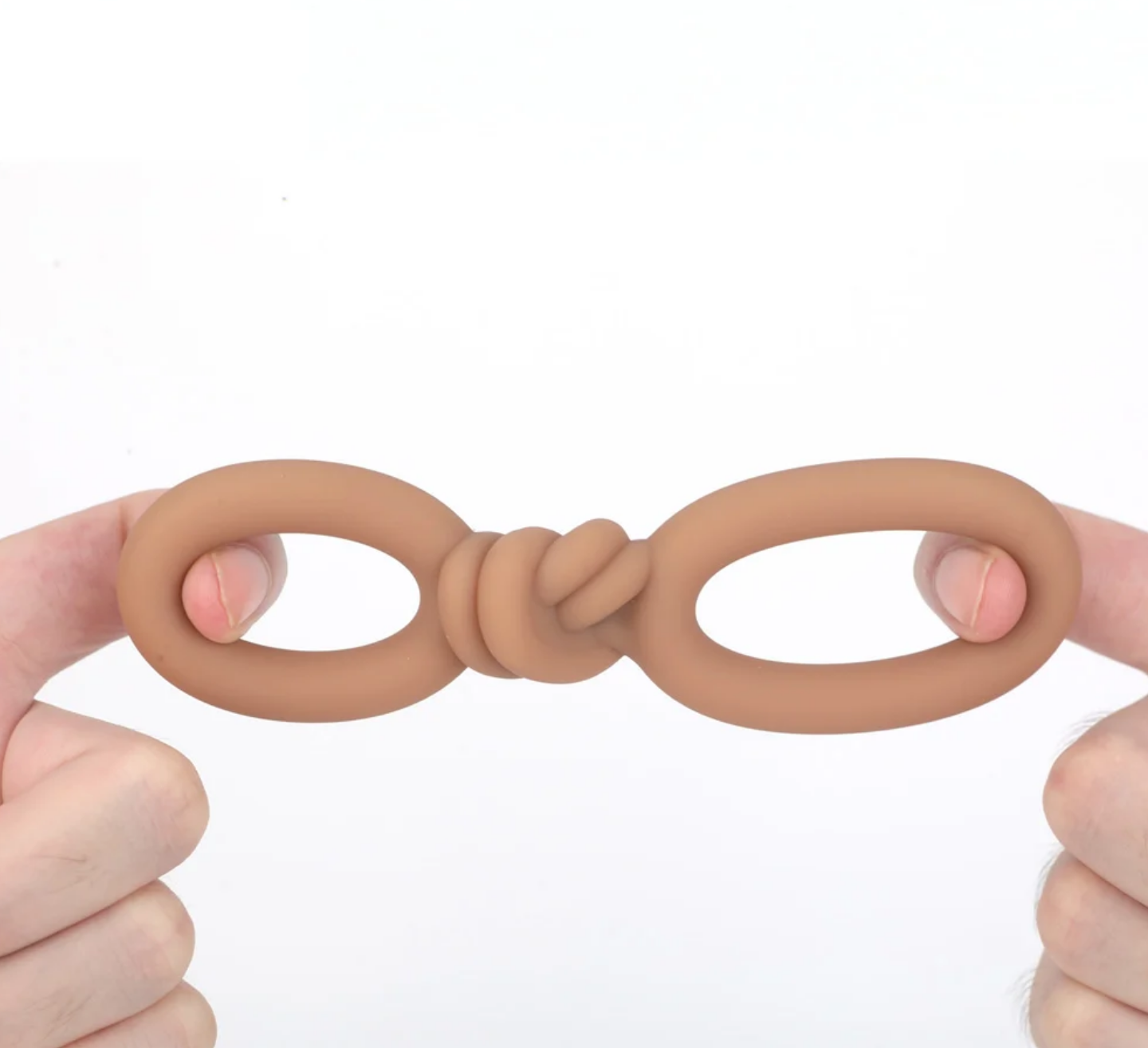 Maia Cooper Liquid Silicone Dual Super Stretch C-Ring Caramel held between two fingers, showcasing its flexible design.