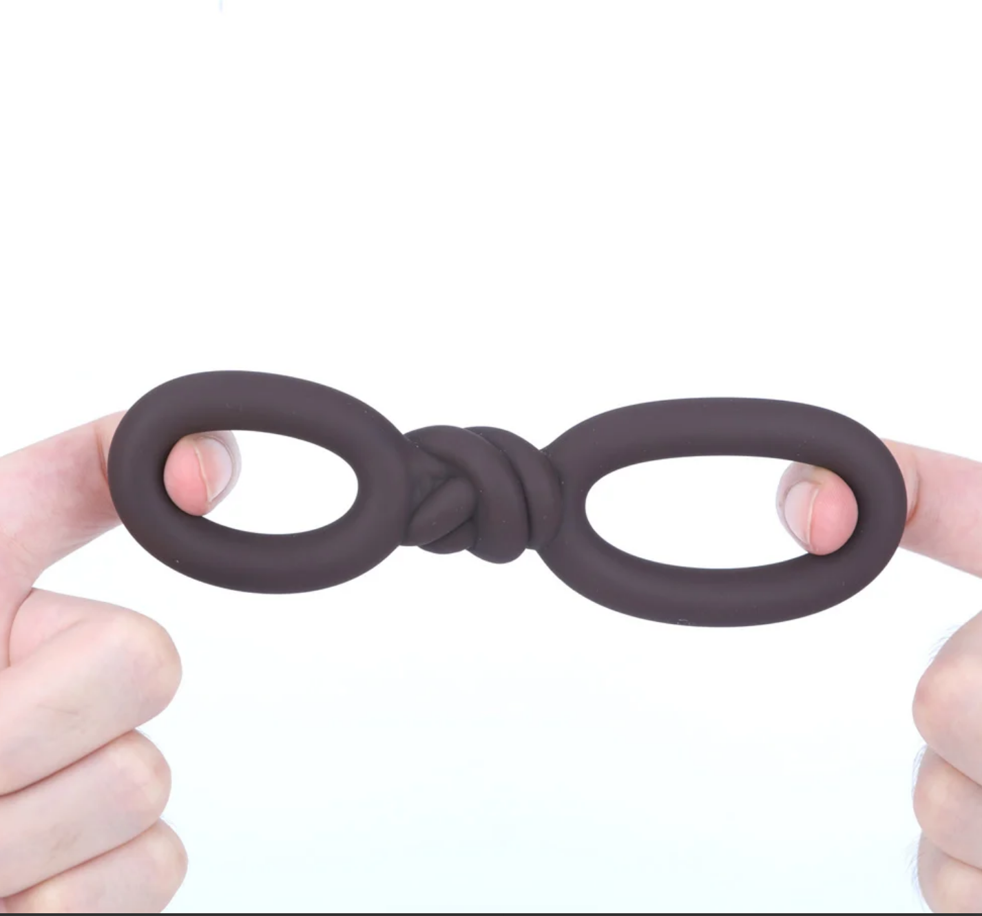 Maia Cooper Liquid Silicone Dual Super Stretch C-Ring Brown displayed in hands, showcasing its unique design and flexibility.