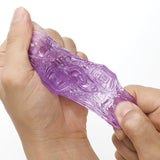 Tenga Uni Variety Pack of 4 Masturbators being squeezed to showcase its stretchy texture and design.