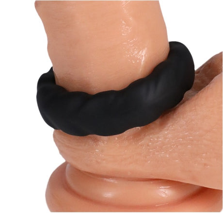 Rock Solid Fat Tire Silicone Cock Ring Black on a skin-toned surface, showcasing its textured design for enhanced stimulation.