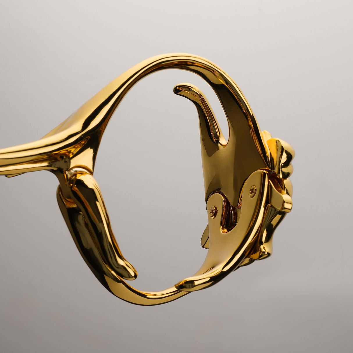 Close-up of UPKO Ripple Metal Handcuffs showcasing polished gold metal design and intricate details.
