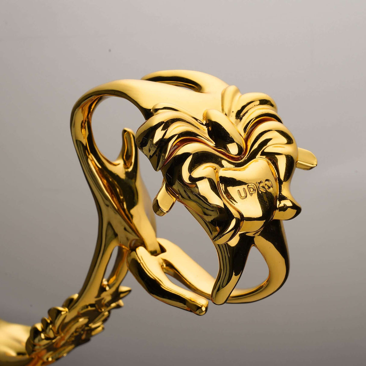 UPKO Ripple Metal Handcuffs in a polished gold finish, showcasing detailed lion design and superior craftsmanship.