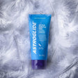 Astroglide Water Gel 3 Oz Water-Based Lubricant in a blue tube on soft feathers.
