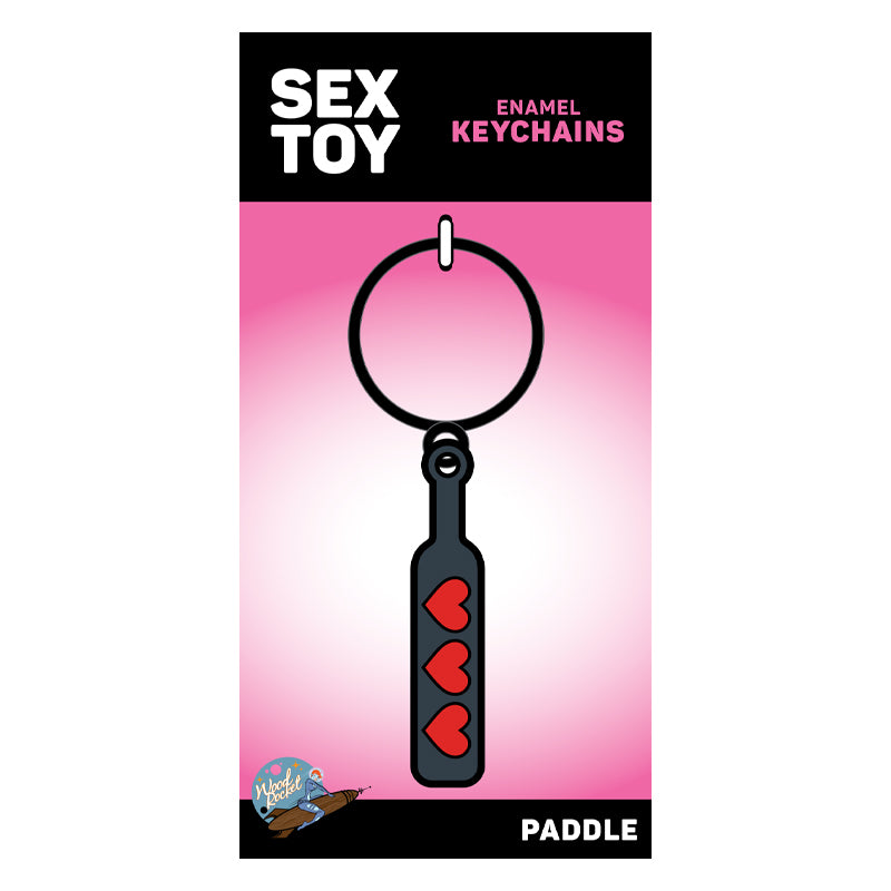 Wood Rocket Heart Paddle Enamel Keychain Black on packaging with playful design and red hearts.