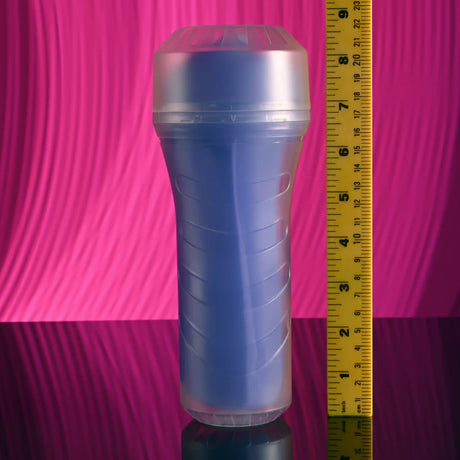 Zero Tolerance Pop On The Glow Pussy Stroker Purple displayed next to a ruler for size reference on a reflective surface.