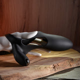Zero Tolerance Nautilus Vibrating Penis Sleeve Black displayed on a wooden surface, featuring a sleek design with cut-out openings.