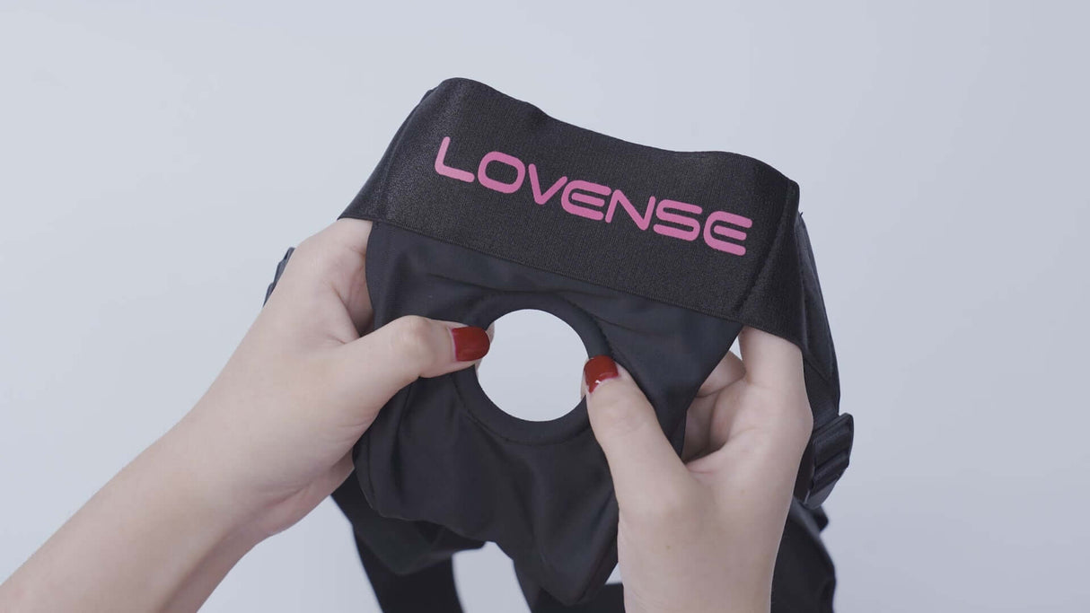 Lovense Strapless Harness for Lapis held by hands, showcasing its durable design and logo.
