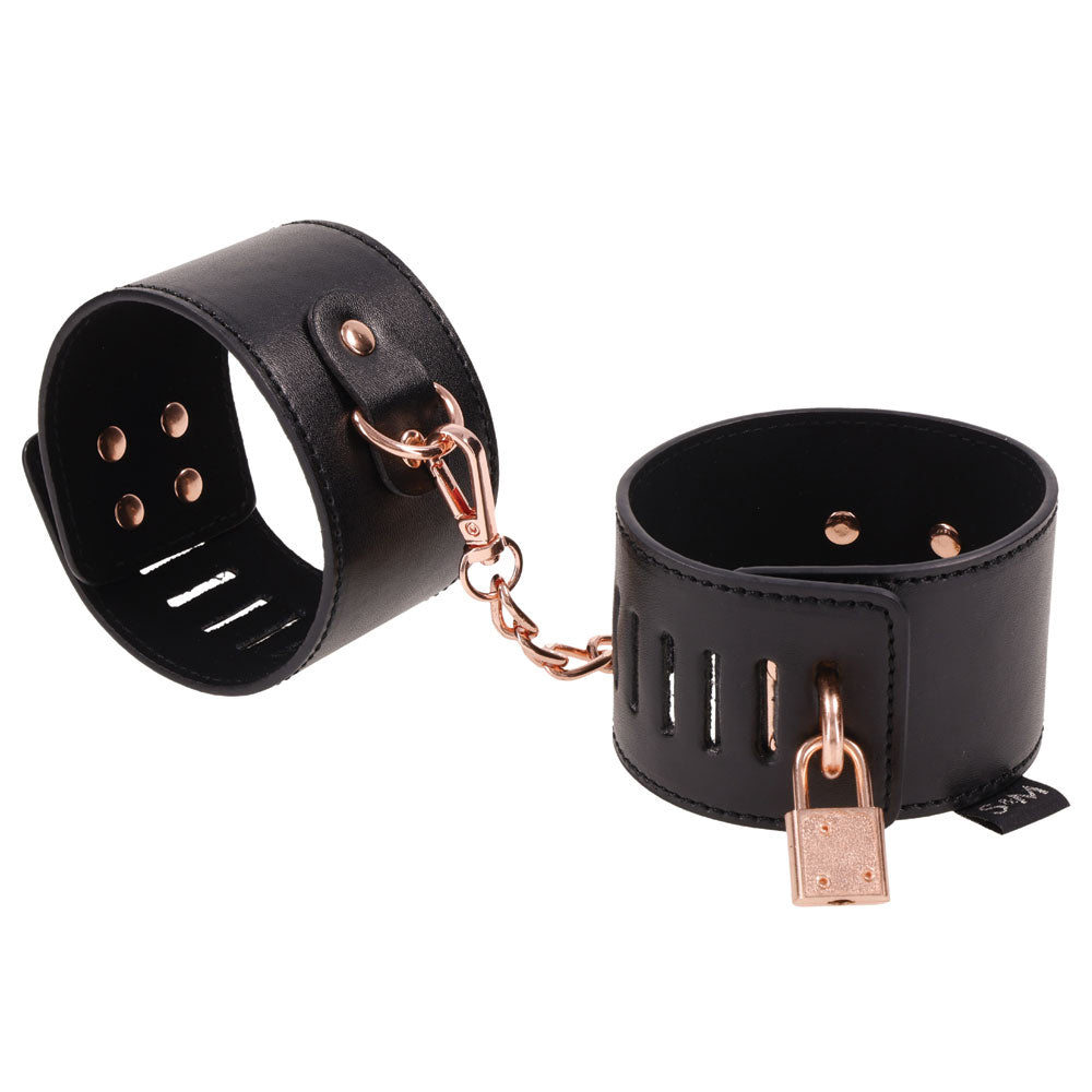Sex and Mischief Brat Locking Cuffs Rose Gold Black featuring sleek black vegan leather and rose gold accents.