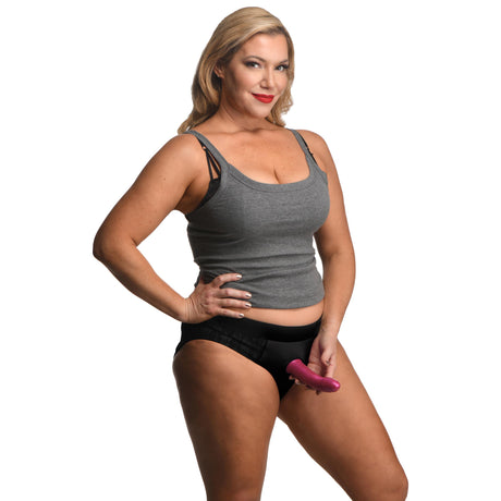 Strap U Lace Envy Black Crotchless Panty Harness 3 XL model wearing a gray tank top and black underwear with a dildo.