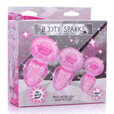 Booty Sparks Glitter Gem Anal Plug Set Pink packaging featuring three pink glittery anal plugs of different sizes.