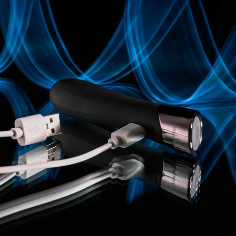 Evolved Back In Black Rechargeable Silicone Bullet with USB charging cable on reflective surface.