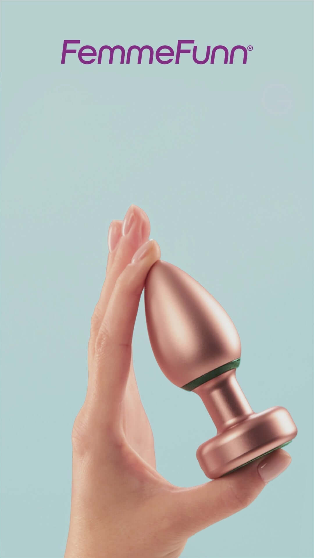 FemmeFunn Bougie Plug Rose Gold held in hand against a light blue background, showcasing its elegant design.