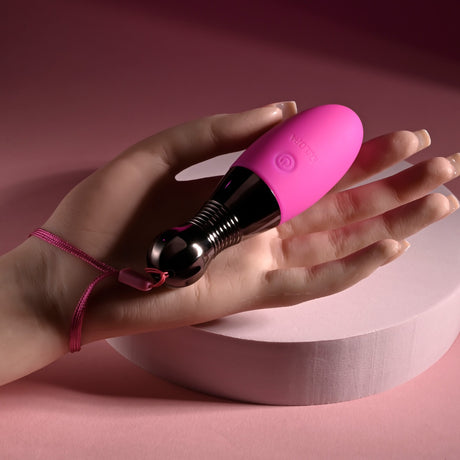 Selopa Companion Rechargeable Silicone Egg Pink held in hand showcasing sleek design and chrome handle.