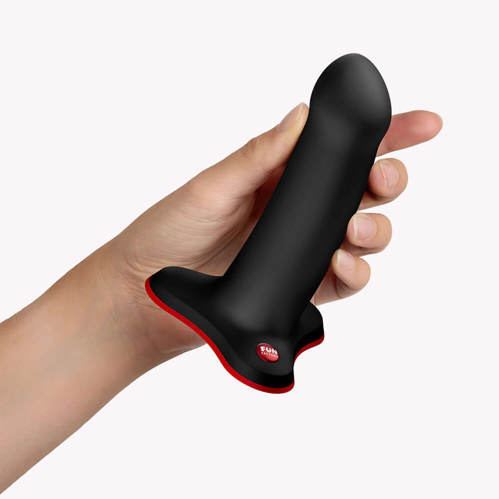 Hand holding the Fun Factory Amor G-Spot Silicone Dildo Black with a curved profile for targeted stimulation.