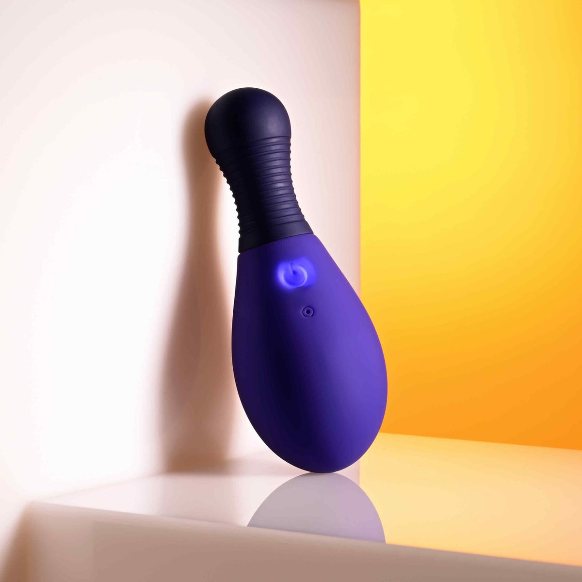 Selopa Egg Me On Remote Control Egg Vibrator Purple resting against a wall with a colorful background.