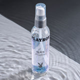 Playboy Pleasure Slick Silicone Lubricant 4 Oz bottle on a smooth surface showcasing its premium quality and design.