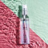 Playboy Pleasure Slick Silicone Lubricant 4 Oz bottle on a colorful background of pink and green.