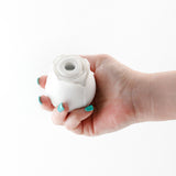 Inya the Rose Glow in the Dark Suction White held in hand, showcasing its elegant floral design and compact form.