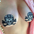 Pastease Skull Black Glitter Candy Pasties on skin, showcasing a whimsical skull and crossbones design for edgy style.