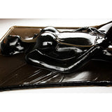 Extreme Black Latex Vacuum Bed with occupant tightly sealed in glossy black latex.