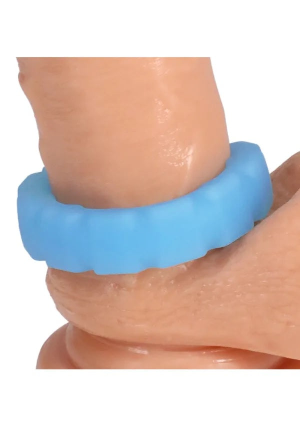 Rock Solid Tire Blue Glow Silicone Cock Ring worn on a hand model for enhanced grip and sensation during play.