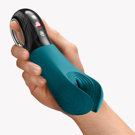 Fun Factory Manta Vibrating Stroker Green held in a hand, showcasing its ergonomic design and vibrant color.